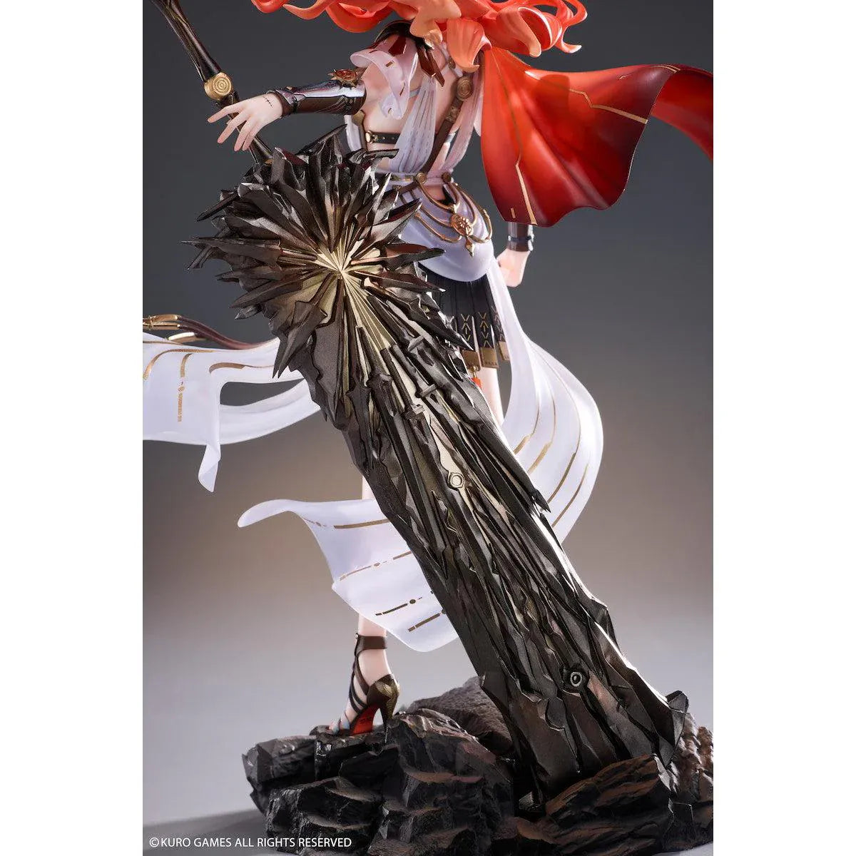 Wuthering Waves Augusta 1/7 Scale Figure with orange-red hair, white-and-gold outfit, armor accents, weapon accessory, and rocky display base
