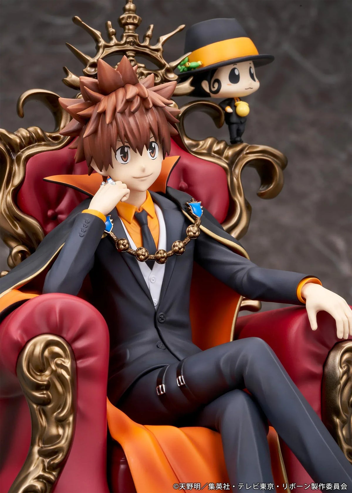 REBORN! Tsunayoshi Sawada & Reborn Scale Figure featuring Tsuna with spiky brown hair, a fiery Dying Will Flame, black suit, and orange-lined cape seated on an ornate golden throne with red upholstery, accompanied by Reborn in his signature fedora.