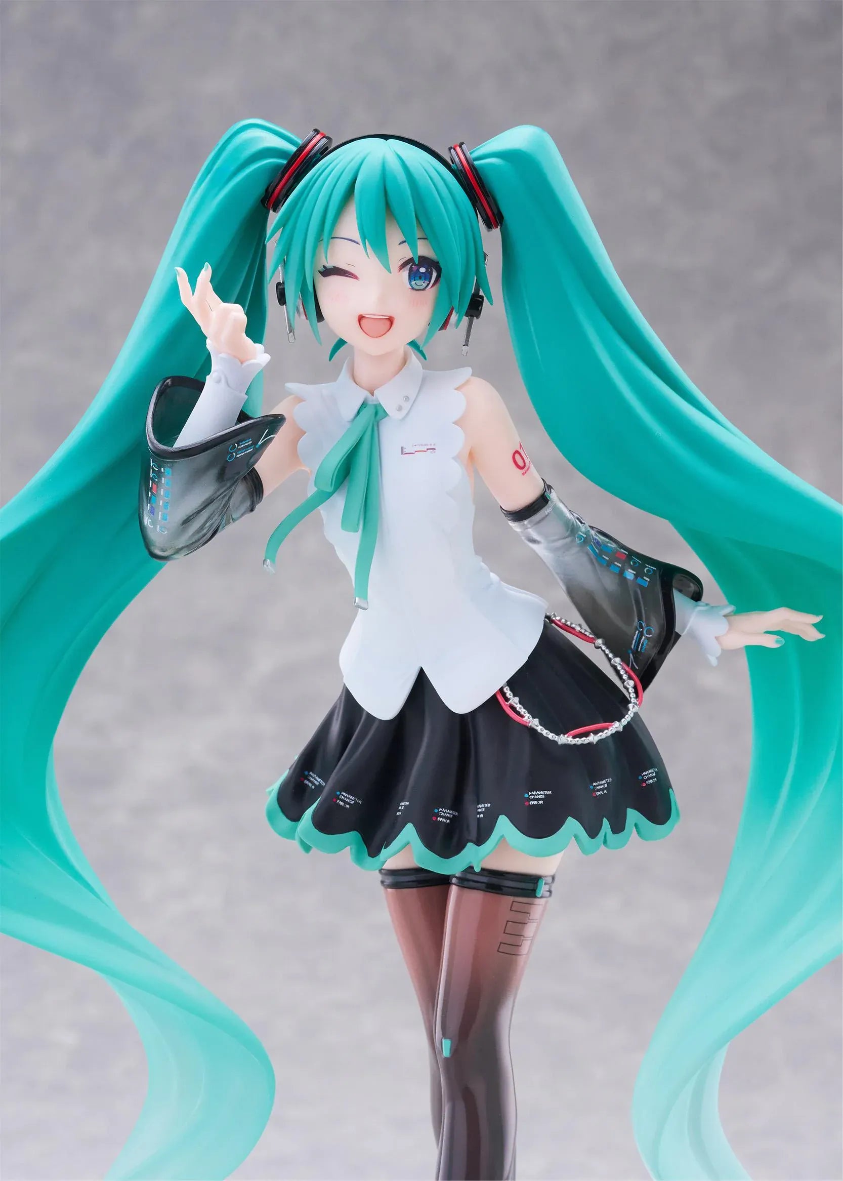 Vocaloid T-Most Hatsune Miku NT Ver. Figure featuring Miku with long teal twin tails, headphones, black-and-white outfit, wink expression, peace-sign pose, and star-themed base.