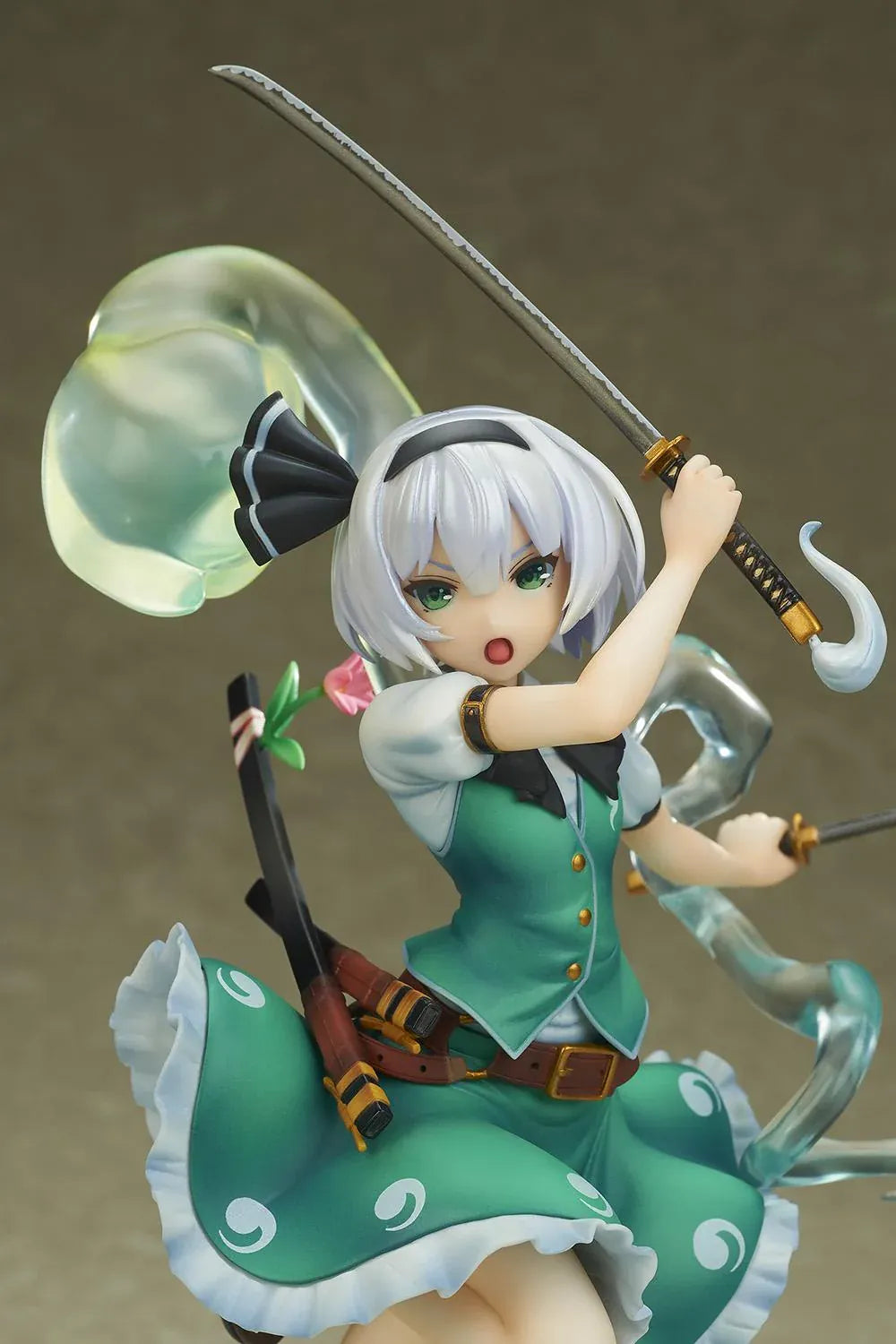 Touhou Project Youmu Konpaku figure wielding two swords in an airborne pose, wearing a green outfit with a translucent swirling spirit effect.