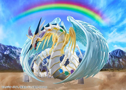 Yu-Gi-Oh! GX Rainbow Dragon figure with a pearlescent armored body, multicolored crystals, gold accents, and translucent blue wings.