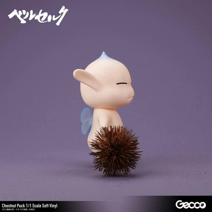 Berserk Chestnut Puck 1/1 Scale Soft Vinyl Figure by Gecco featuring a small cream-colored elf with oversized pointed ears, a tiny blue hair tuft, closed eyes, a grumpy expression, and a rounded body holding a large spiky brown chestnut burr.