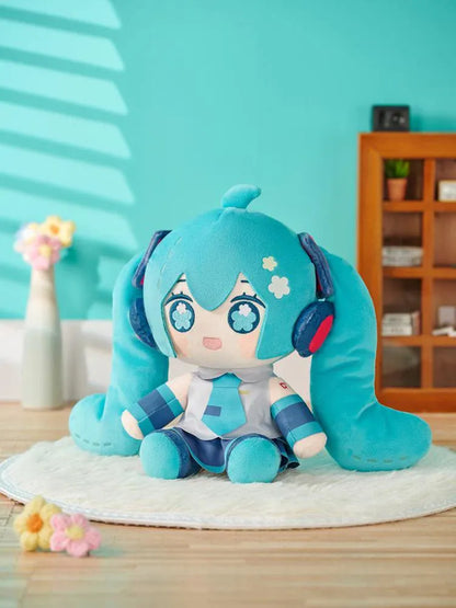 Hatsune Miku Huggy Doll plushie with turquoise twin tails, flower-shaped embroidered eyes, and her signature outfit.