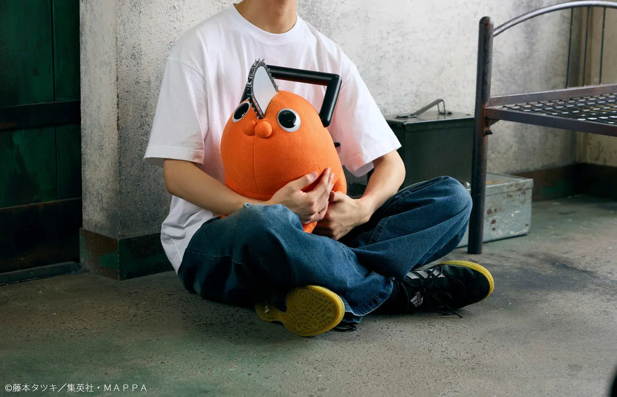 Chainsaw Man life-size Pochita doll figure with an orange body, glossy eyes, chainsaw blade, black handle, and pull cord.