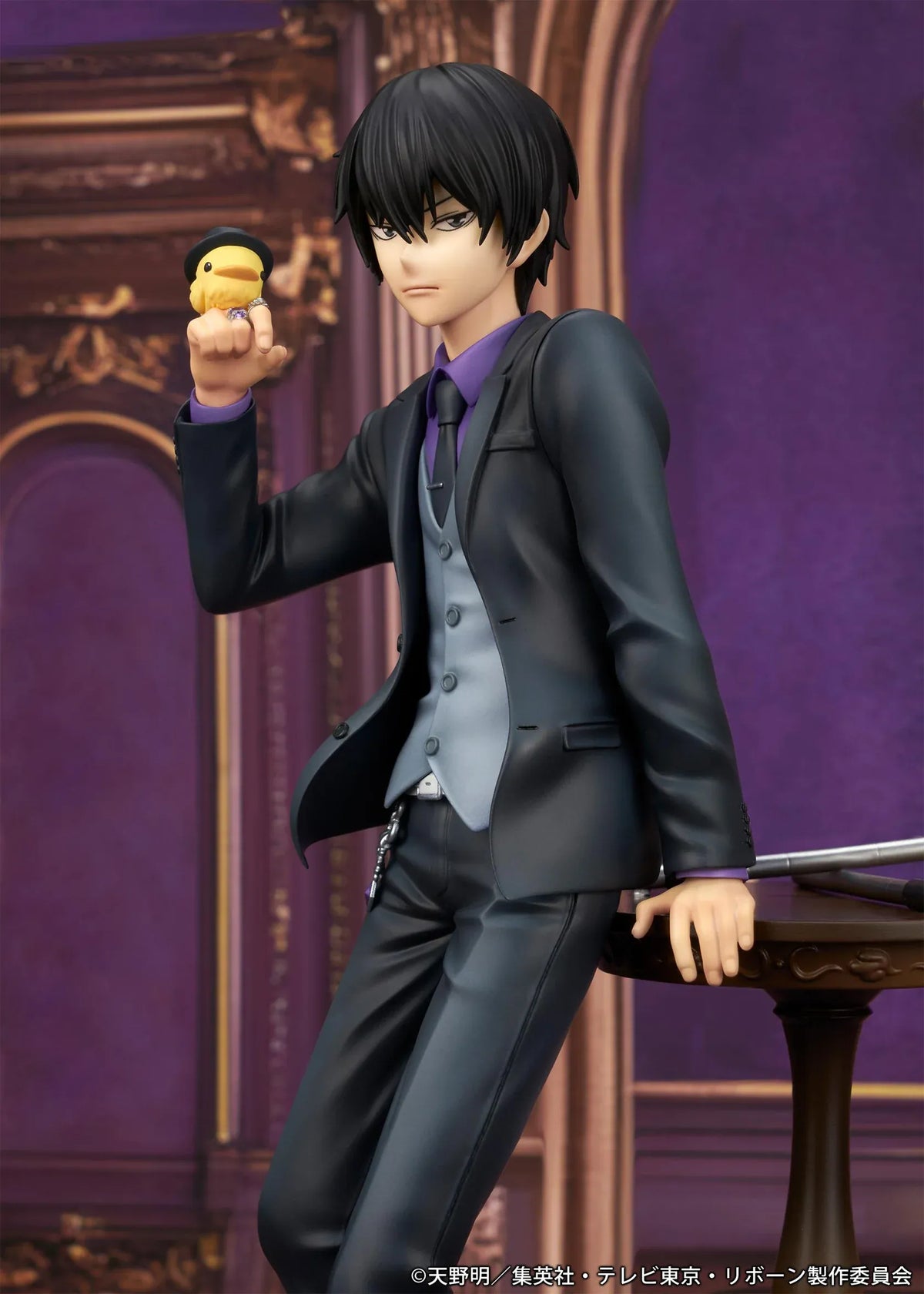 REBORN! Kyoya Hibari Scale Figure featuring a black-haired anime character wearing a black suit, purple shirt, gray vest, and tie, leaning against a wooden table with tonfa weapons while holding his yellow bird companion Hibird.