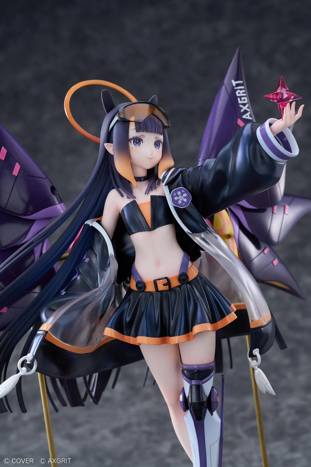 Ninomae Ina’nis AXGRIT Ver. figure with flowing dark hair, an oversized jacket, armored boots, purple mechanical elements, and orange rings above a circular base.