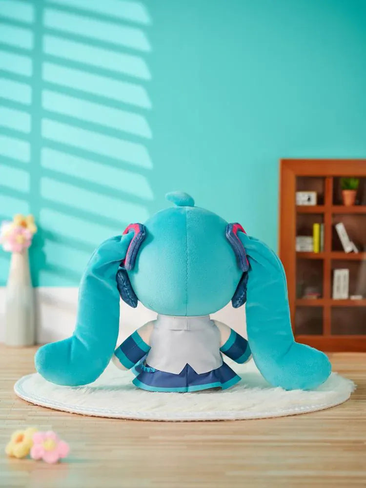 Hatsune Miku Huggy Doll plushie with turquoise twin tails, flower-shaped embroidered eyes, and her signature outfit.
