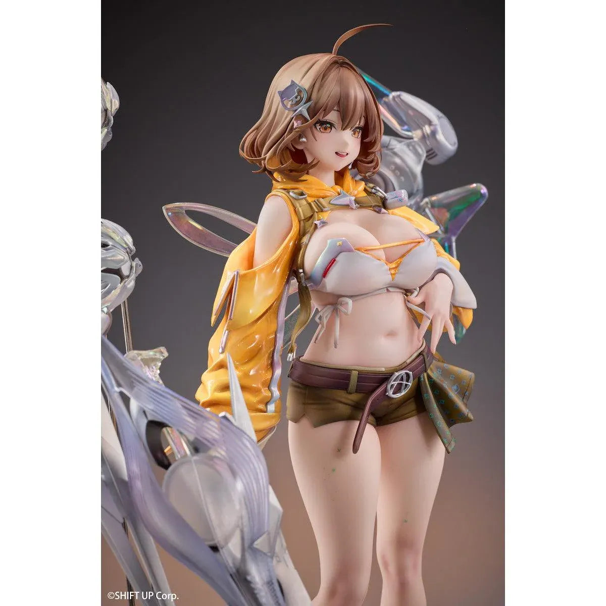 GODDESS OF VICTORY: NIKKE Anis: Star 1/7 Scale Figure featuring a brown-haired anime girl wearing a yellow jacket, white top, olive-green shorts, and sneakers, surrounded by futuristic floating mechanical accessories on a detailed display base.