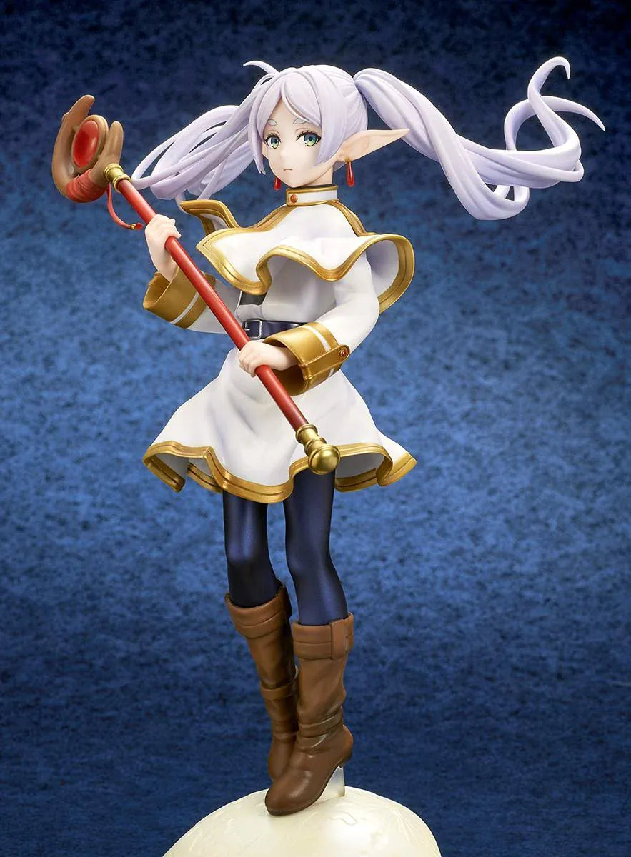 Frieren vs Aura 1/7 scale figure holding a red staff while wearing her white-and-gold mage outfit on a rounded display base.