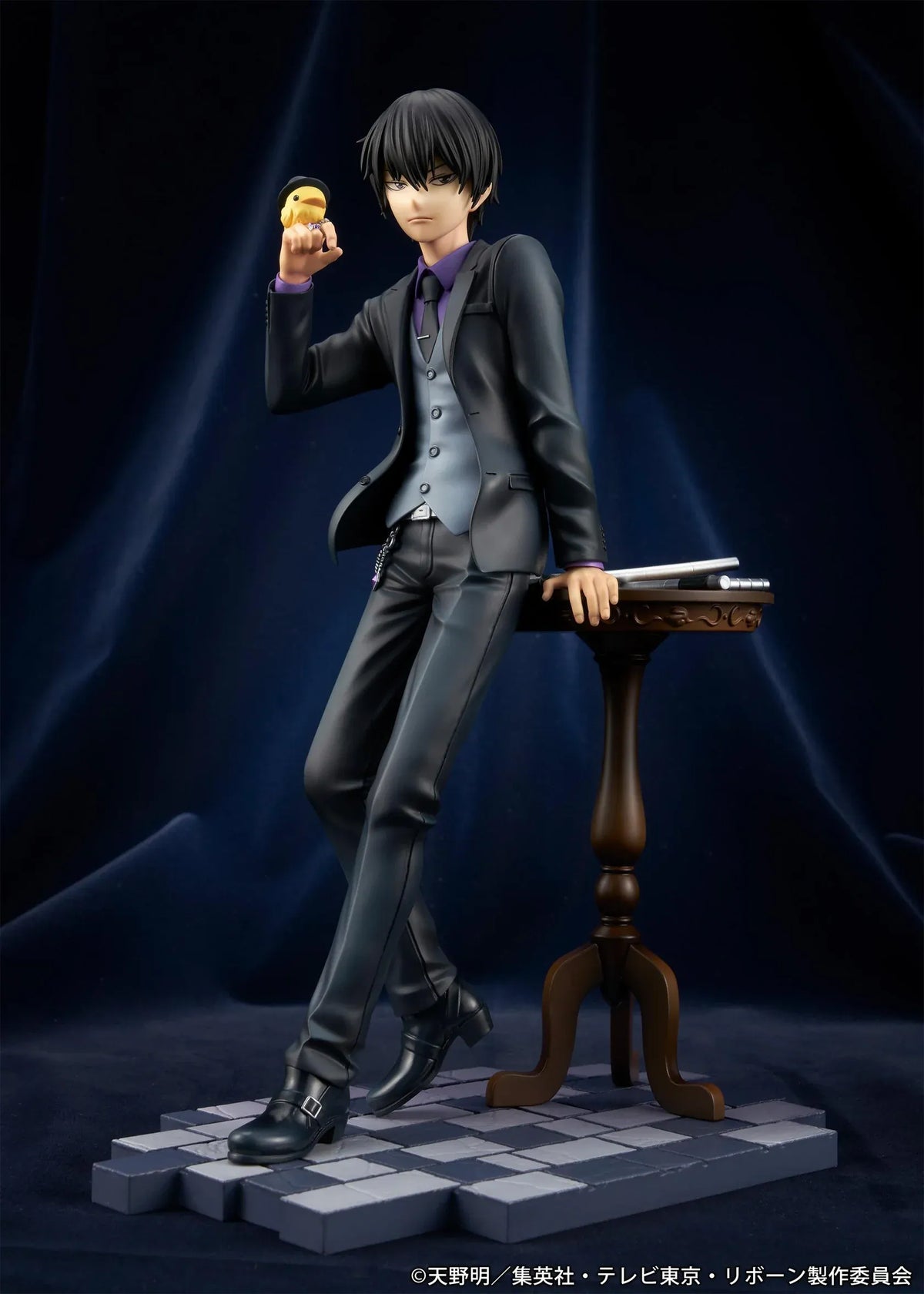 REBORN! Kyoya Hibari Scale Figure featuring a black-haired anime character wearing a black suit, purple shirt, gray vest, and tie, leaning against a wooden table with tonfa weapons while holding his yellow bird companion Hibird.