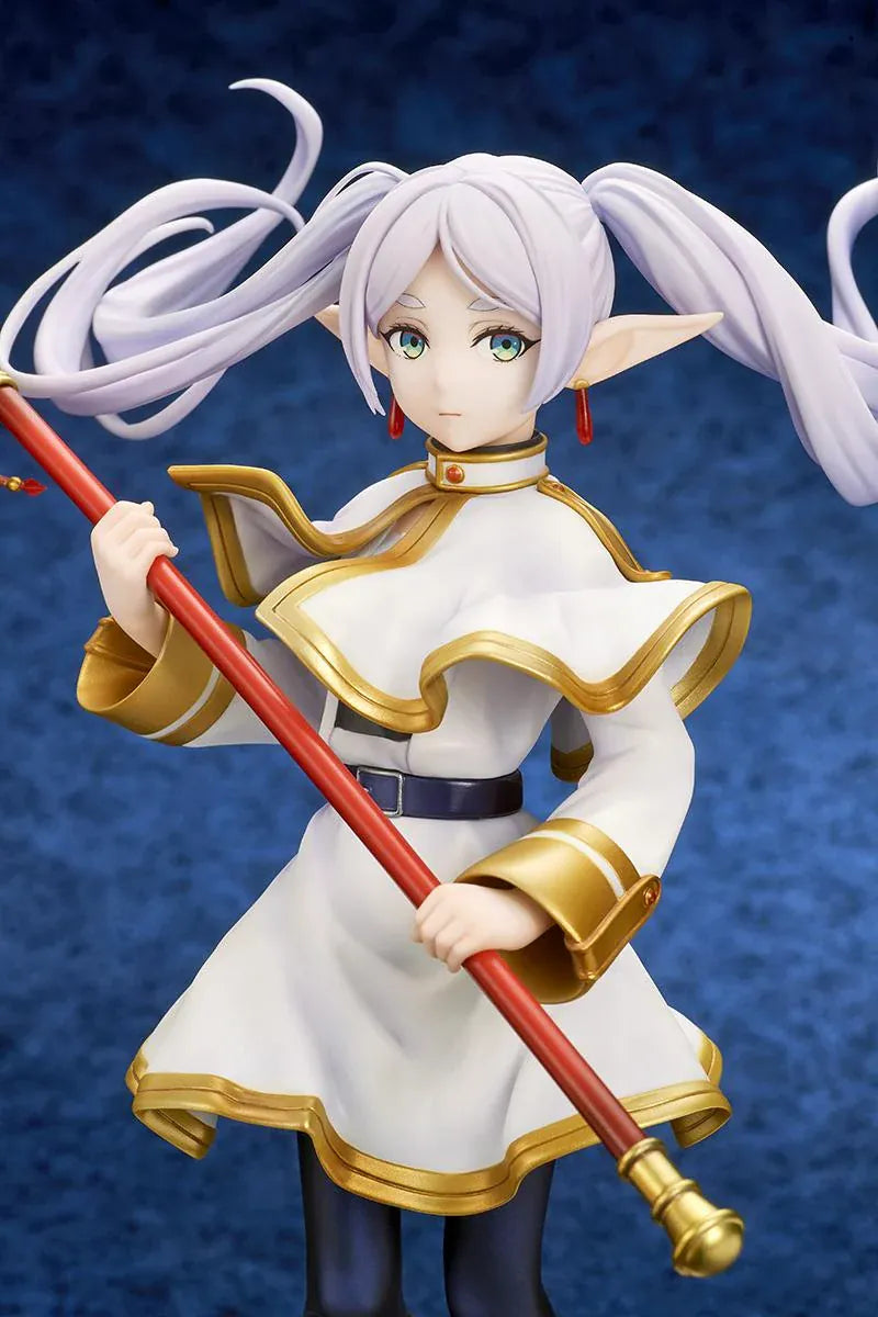 Frieren vs Aura 1/7 scale figure holding a red staff while wearing her white-and-gold mage outfit on a rounded display base.