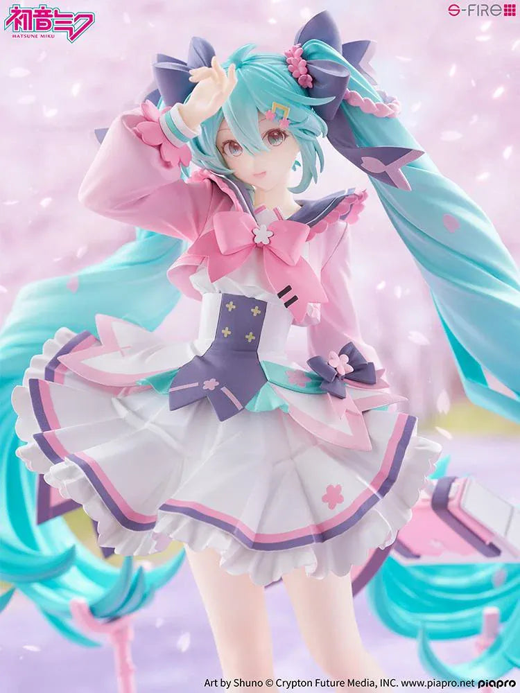 Hatsune Miku New School Term figure with turquoise twin-tails, a pink and white ruffled outfit, purple bows, and flower accents on a pink base.