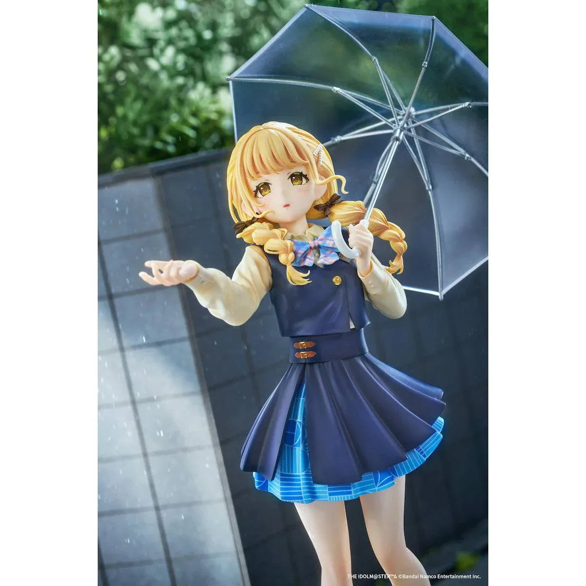 Gakuen iDOLM@STER Kotone Fujita Ameagari no Iris Before Special Training Ver. 1/7 Scale Figure featuring a blonde-haired anime girl with twin braids wearing a navy-blue school uniform and holding a transparent umbrella on a yellow display base.