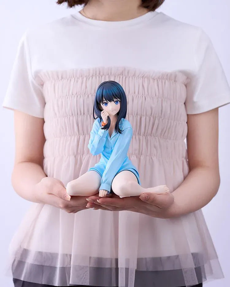 GRIDMAN UNIVERSE Rikka Takarada Pajamas Ver. figure seated in light blue pajamas, with dark hair, blue eyes, and an orange wrist scrunchie.
