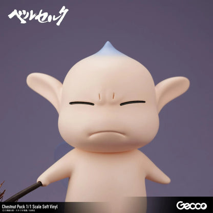 Berserk Chestnut Puck 1/1 Scale Soft Vinyl Figure by Gecco featuring a small cream-colored elf with oversized pointed ears, a tiny blue hair tuft, closed eyes, a grumpy expression, and a rounded body holding a large spiky brown chestnut burr.
