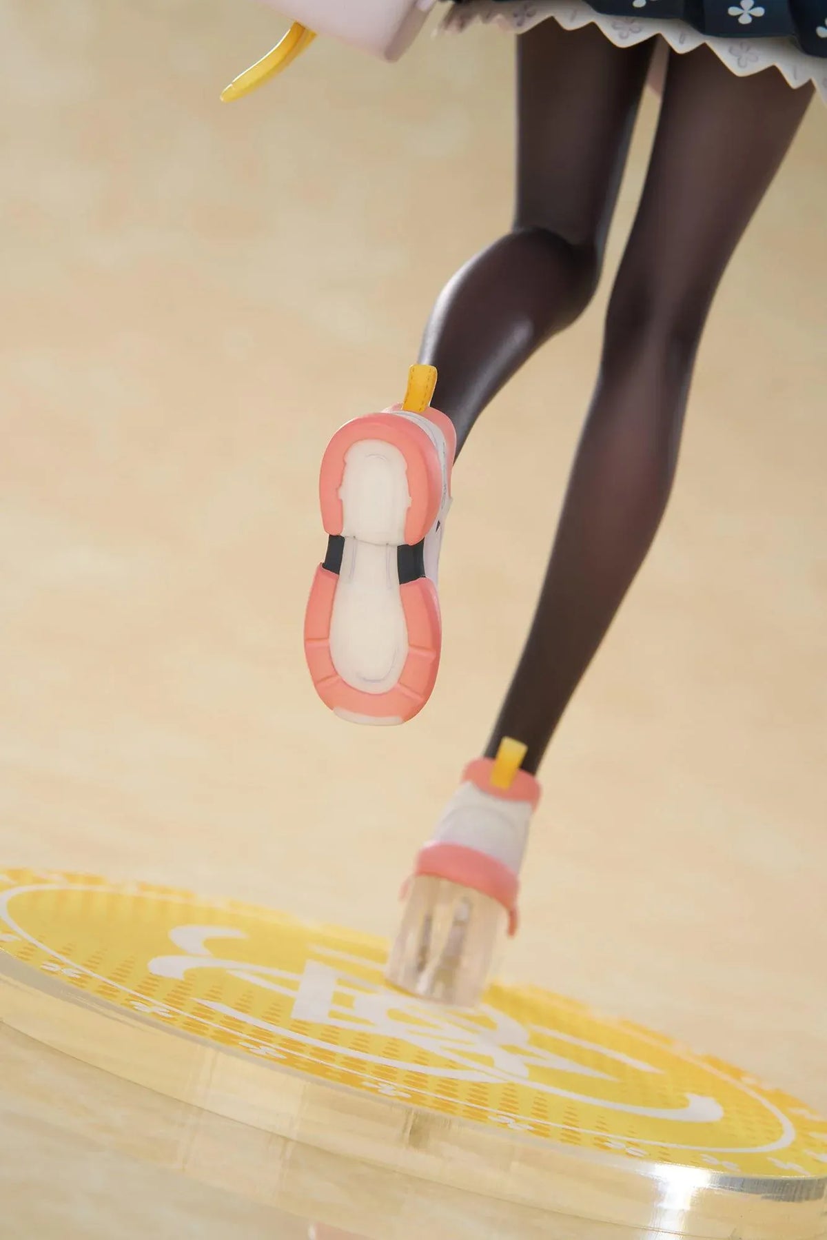 Blue Archive Hifumi figure smiling with one foot lifted, wearing a white cardigan and navy skirt, carrying a bird-themed bag and rifle on a yellow base.