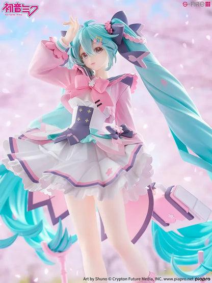Hatsune Miku New School Term figure with turquoise twin-tails, a pink and white ruffled outfit, purple bows, and flower accents on a pink base.