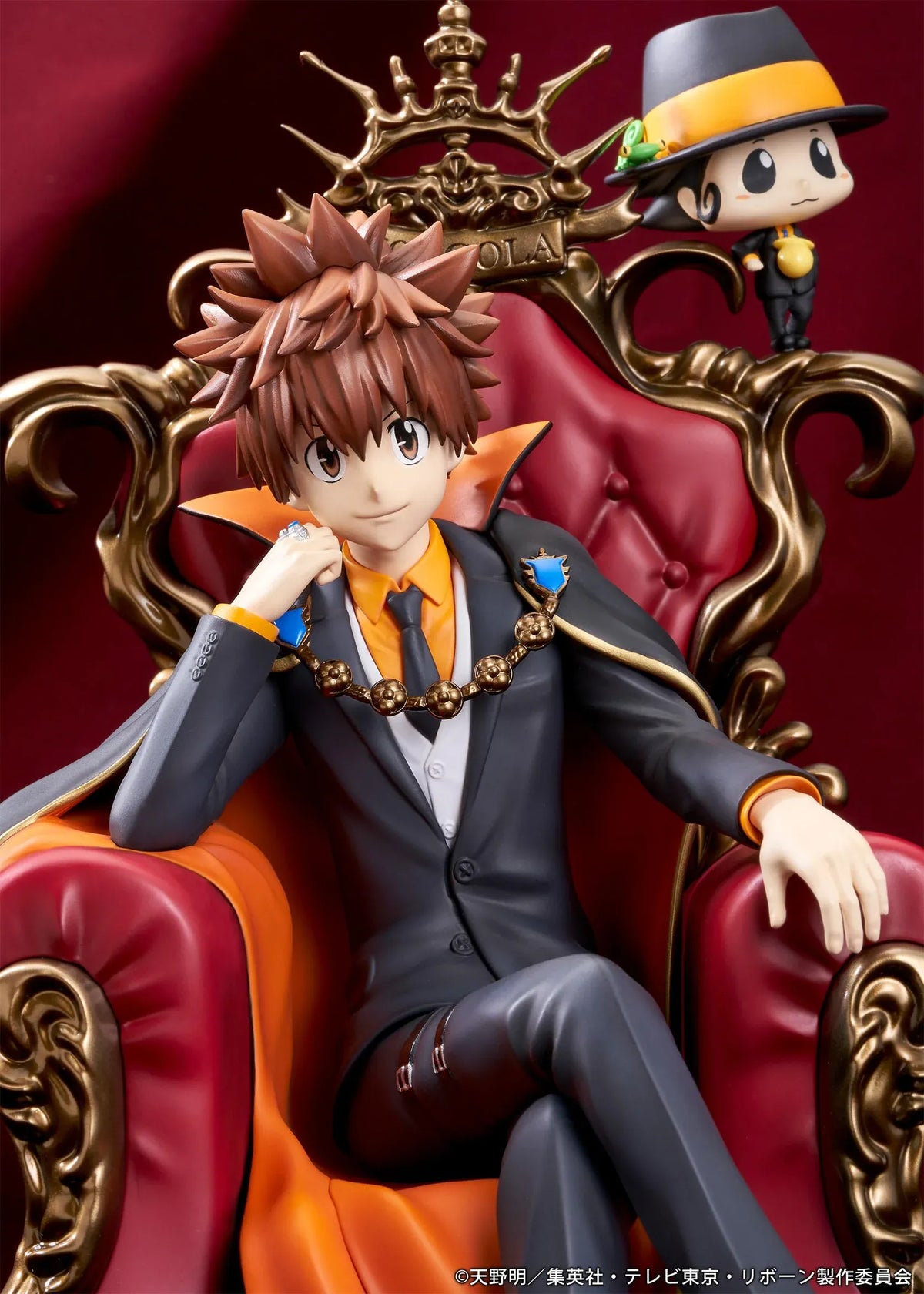REBORN! Tsunayoshi Sawada & Reborn Scale Figure featuring Tsuna with spiky brown hair, a fiery Dying Will Flame, black suit, and orange-lined cape seated on an ornate golden throne with red upholstery, accompanied by Reborn in his signature fedora.