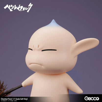 Berserk Chestnut Puck 1/1 Scale Soft Vinyl Figure by Gecco featuring a small cream-colored elf with oversized pointed ears, a tiny blue hair tuft, closed eyes, a grumpy expression, and a rounded body holding a large spiky brown chestnut burr.