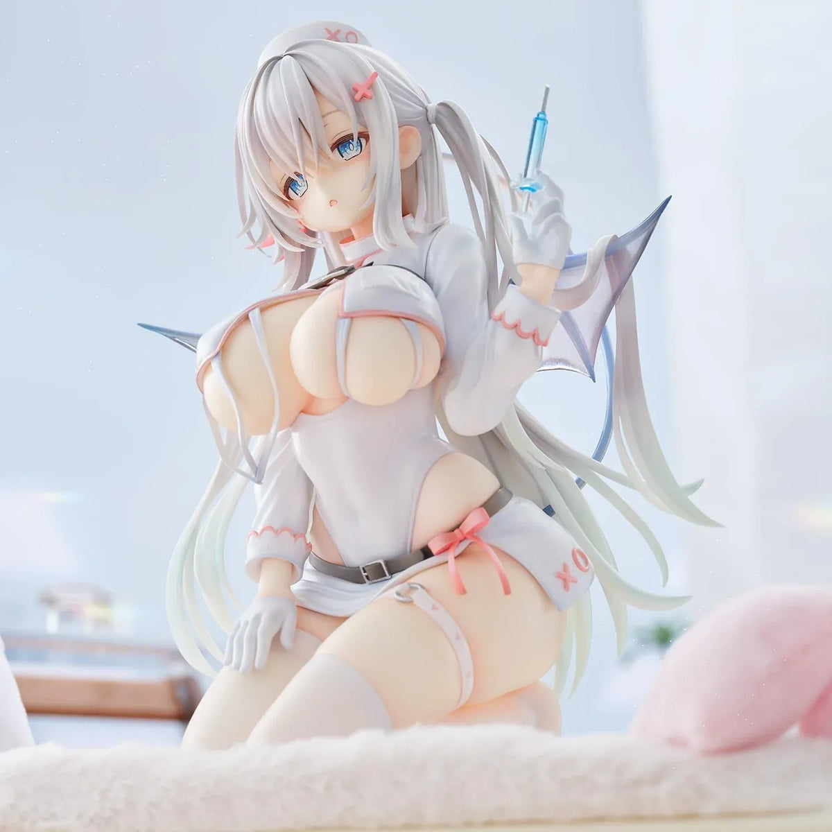 Succubus Nurse Makina figure kneeling in a white and pink nurse outfit with silver hair, batlike wings, a demon tail, and a translucent syringe.