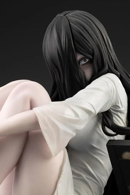Sadako BISHOUJO Sadako 1/7 Scale Figure (Rerelease) featuring a long black-haired horror character wearing a flowing white dress, seated above a pile of VHS tapes with tangled black film ribbons.