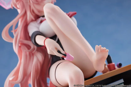 Blue Archive Kirara figure with long pink hair, black horns, and a pink halo, seated on a classroom desk beside nail polish bottles.