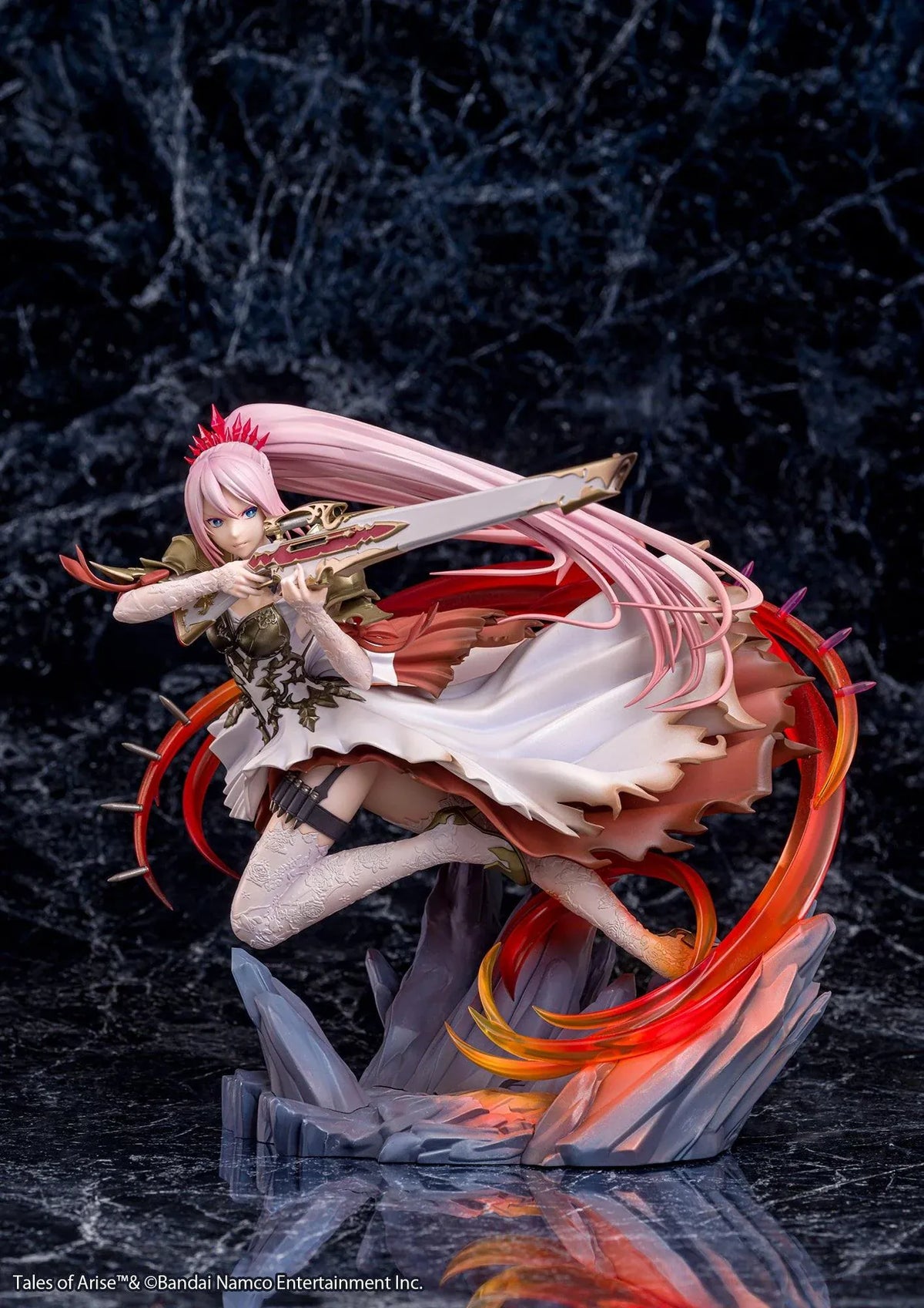 Tales of Arise Shionne 1/7 Scale Figure featuring a pink-haired anime character with blue eyes, an ornate white battle dress, gold armor, and lace stockings, aiming a detailed rifle while suspended in a dynamic pose surrounded by translucent red and orange effects on a rocky display base.