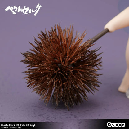 Berserk Chestnut Puck 1/1 Scale Soft Vinyl Figure by Gecco featuring a small cream-colored elf with oversized pointed ears, a tiny blue hair tuft, closed eyes, a grumpy expression, and a rounded body holding a large spiky brown chestnut burr.