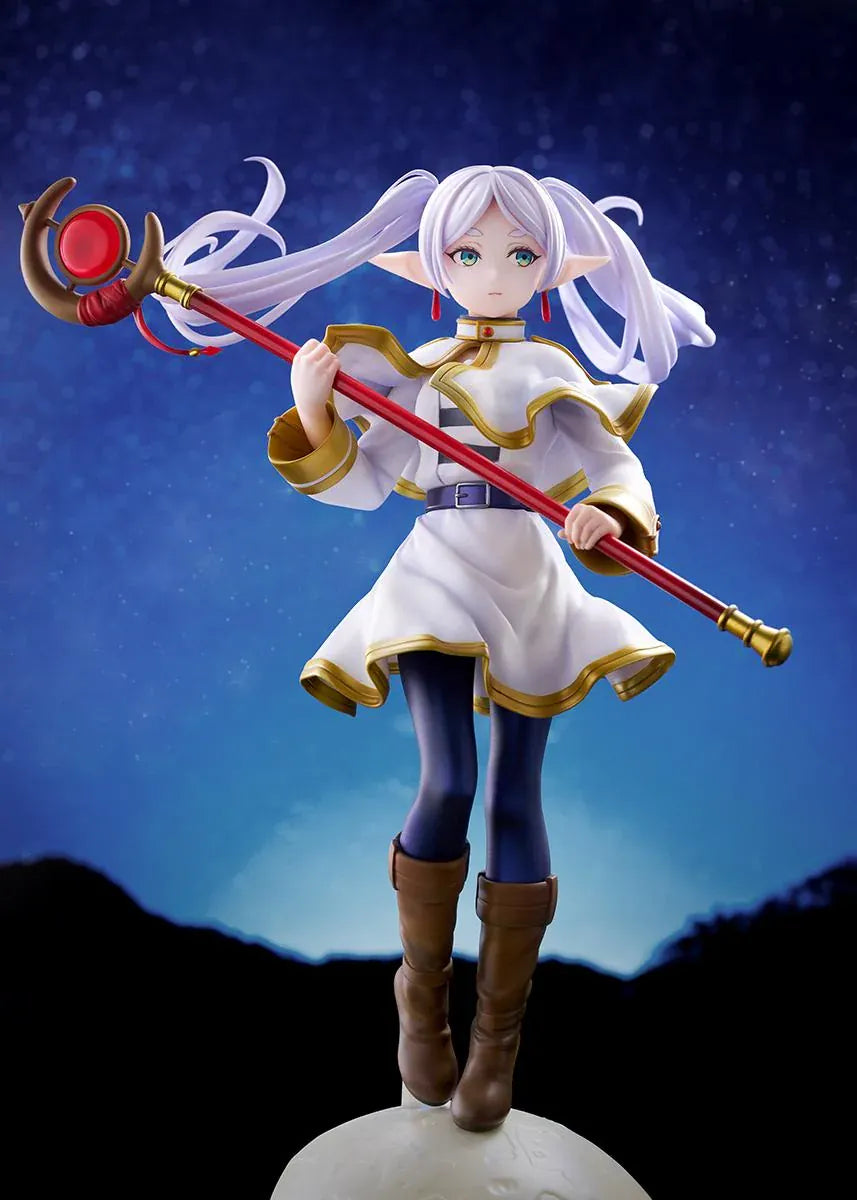 Frieren vs Aura 1/7 scale figure holding a red staff while wearing her white-and-gold mage outfit on a rounded display base.