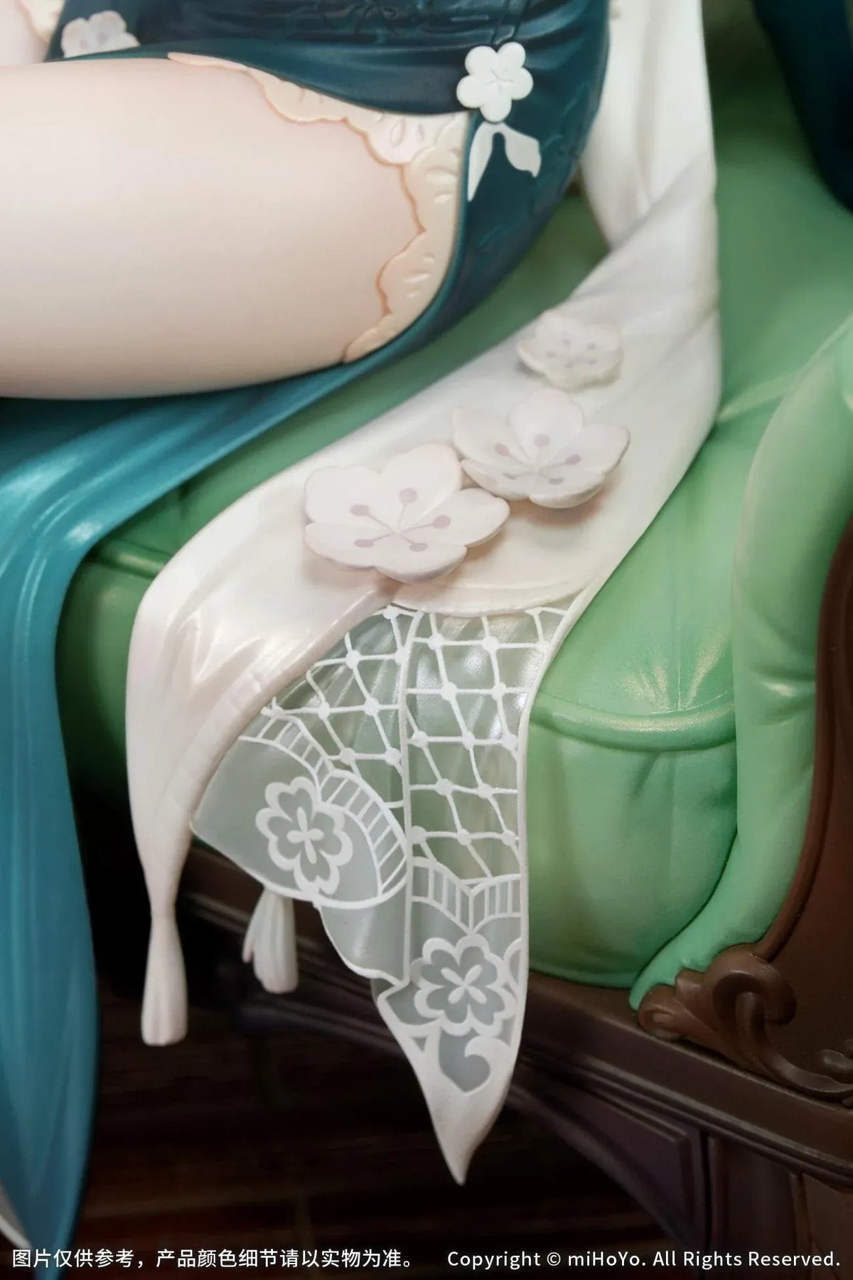 Ruan Mei Plumblossom Letter 1/7 scale figure wearing an elegant teal-and-white floral dress while seated on an ornate green sofa.