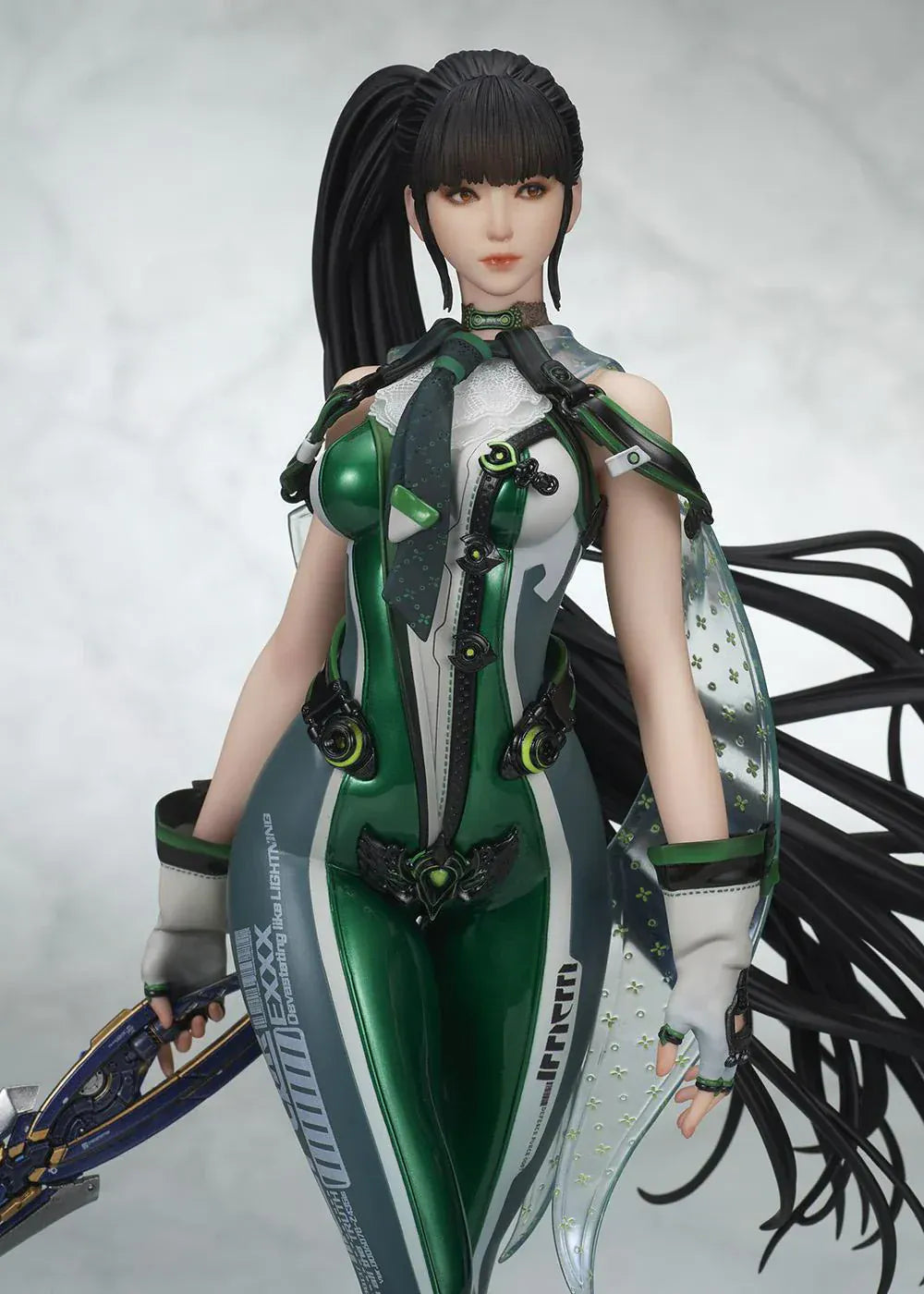 Stellar Blade Eve non-scale figure in a futuristic green and gray combat suit holding a long sword with flowing black hair