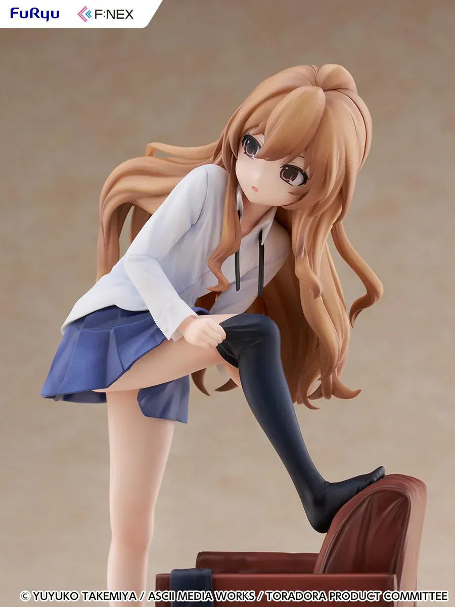1/7 scale Toradora figure of Taiga Aisaka at home, barefoot and leaning on a leather armchair while pulling on a black thigh-high sock, wearing her school shirt and blue skirt.