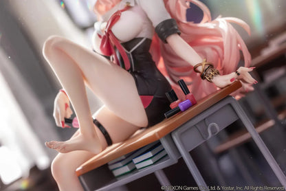 Blue Archive Kirara figure with long pink hair, black horns, and a pink halo, seated on a classroom desk beside nail polish bottles.