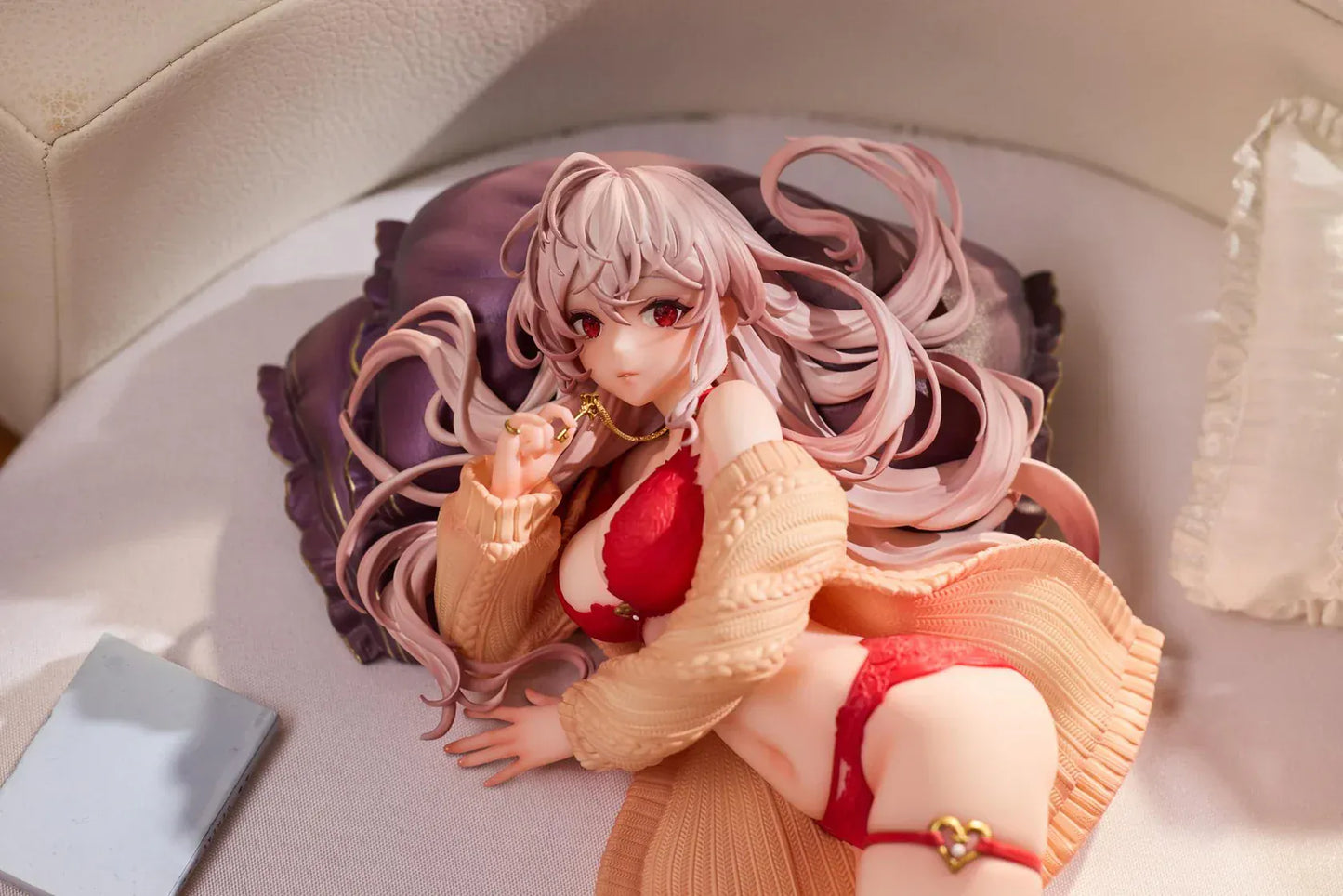 Makia 1/7 scale figure lying on a large fluffy white round base, wearing a cardigan and red lingerie, resting on a purple pillow
