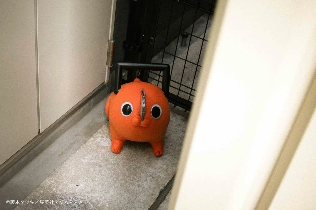 Chainsaw Man life-size Pochita doll figure with an orange body, glossy eyes, chainsaw blade, black handle, and pull cord.