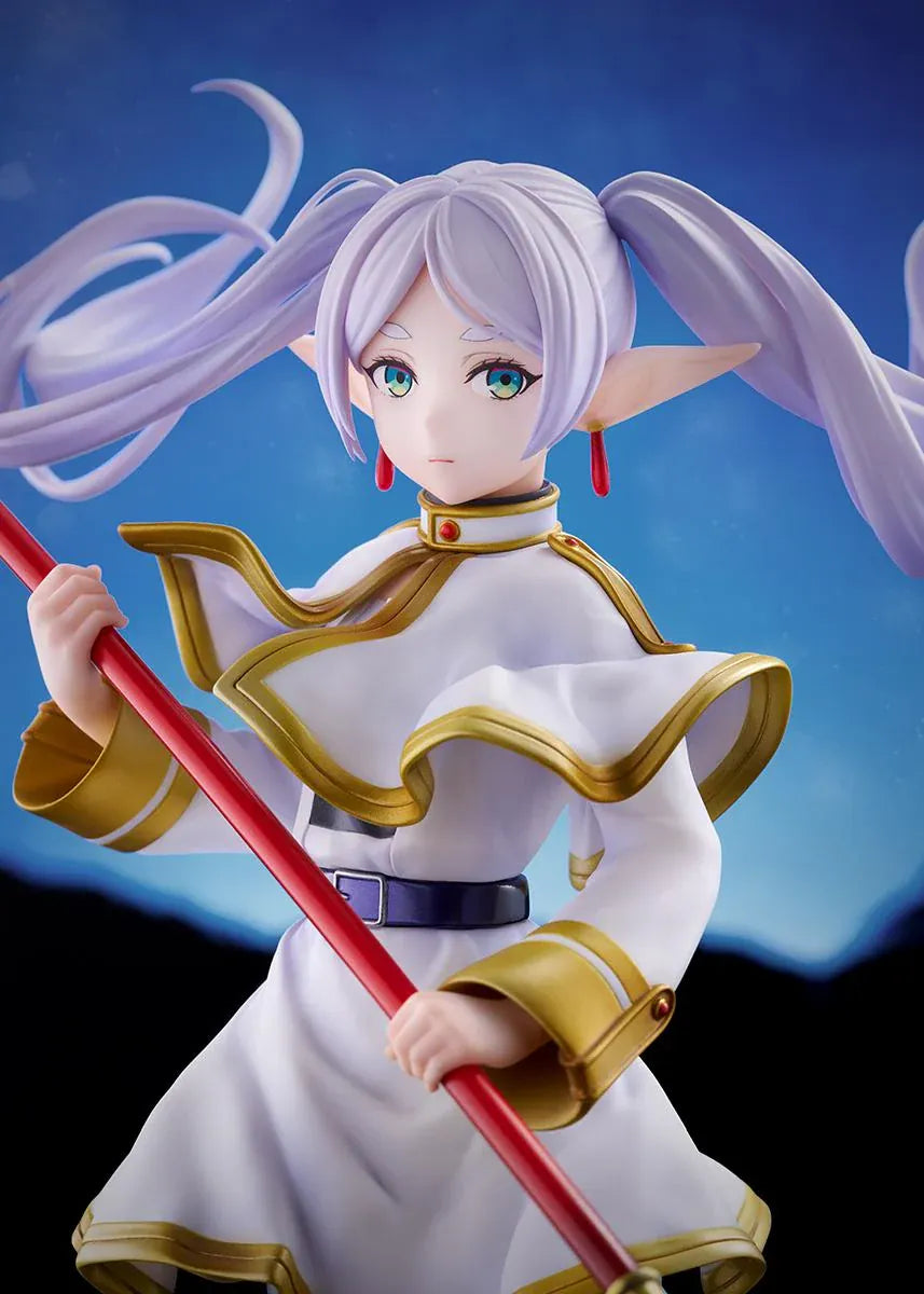 Frieren vs Aura 1/7 scale figure holding a red staff while wearing her white-and-gold mage outfit on a rounded display base.