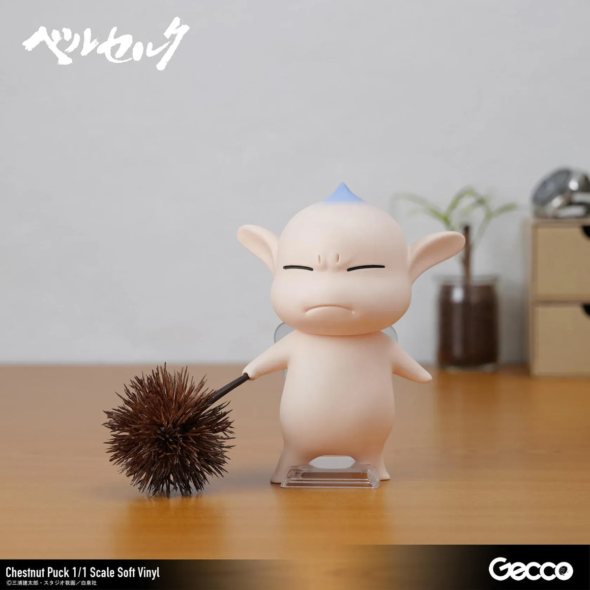 Berserk Chestnut Puck 1/1 Scale Soft Vinyl Figure by Gecco featuring a small cream-colored elf with oversized pointed ears, a tiny blue hair tuft, closed eyes, a grumpy expression, and a rounded body holding a large spiky brown chestnut burr.