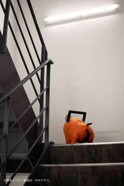 Chainsaw Man life-size Pochita doll figure with an orange body, glossy eyes, chainsaw blade, black handle, and pull cord.