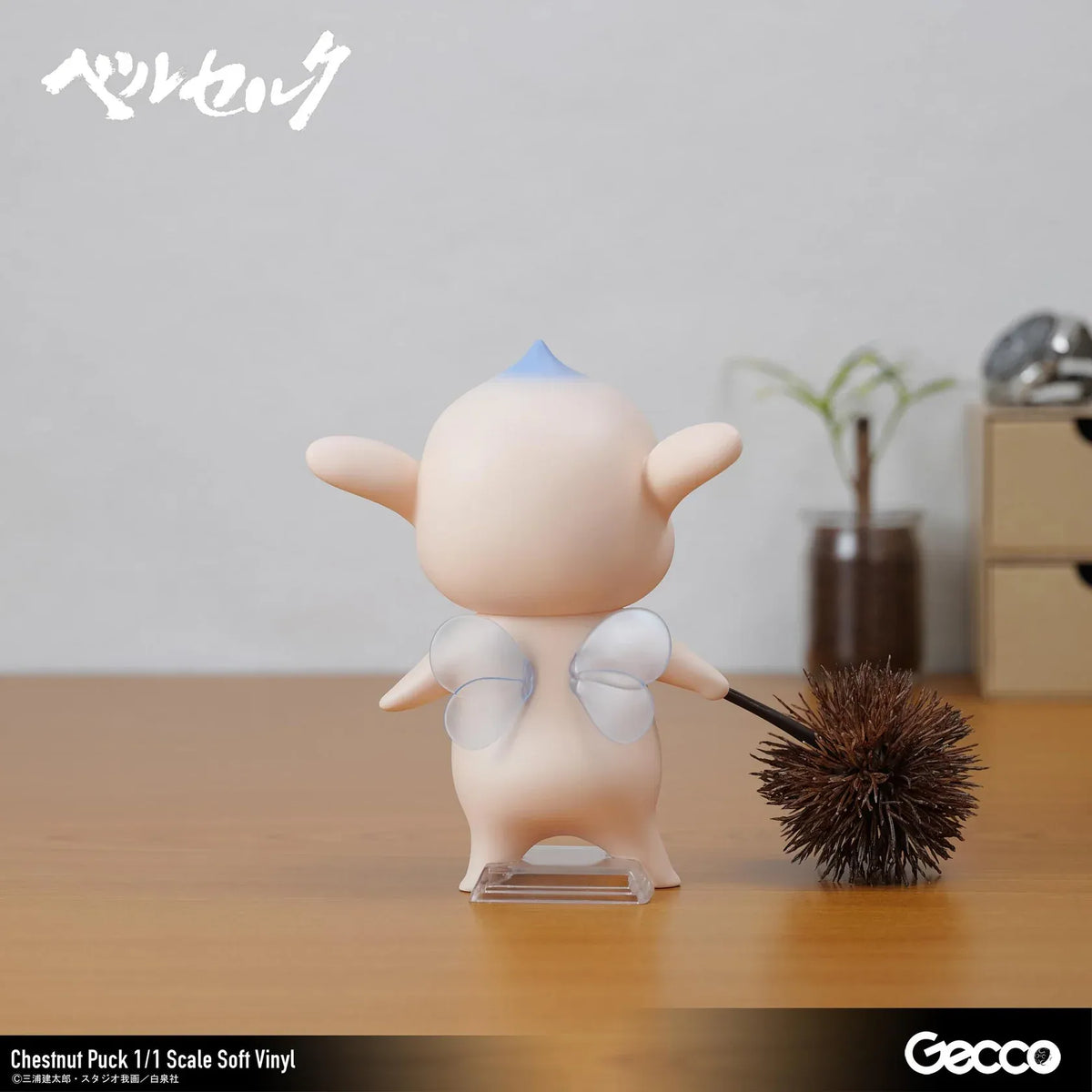 Berserk Chestnut Puck 1/1 Scale Soft Vinyl Figure by Gecco featuring a small cream-colored elf with oversized pointed ears, a tiny blue hair tuft, closed eyes, a grumpy expression, and a rounded body holding a large spiky brown chestnut burr.