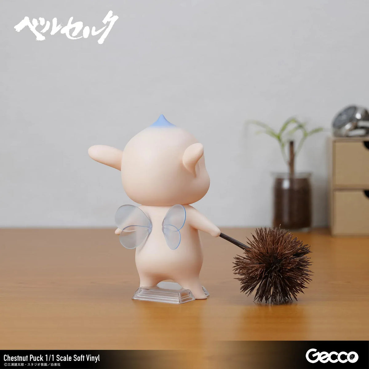 Berserk Chestnut Puck 1/1 Scale Soft Vinyl Figure by Gecco featuring a small cream-colored elf with oversized pointed ears, a tiny blue hair tuft, closed eyes, a grumpy expression, and a rounded body holding a large spiky brown chestnut burr.