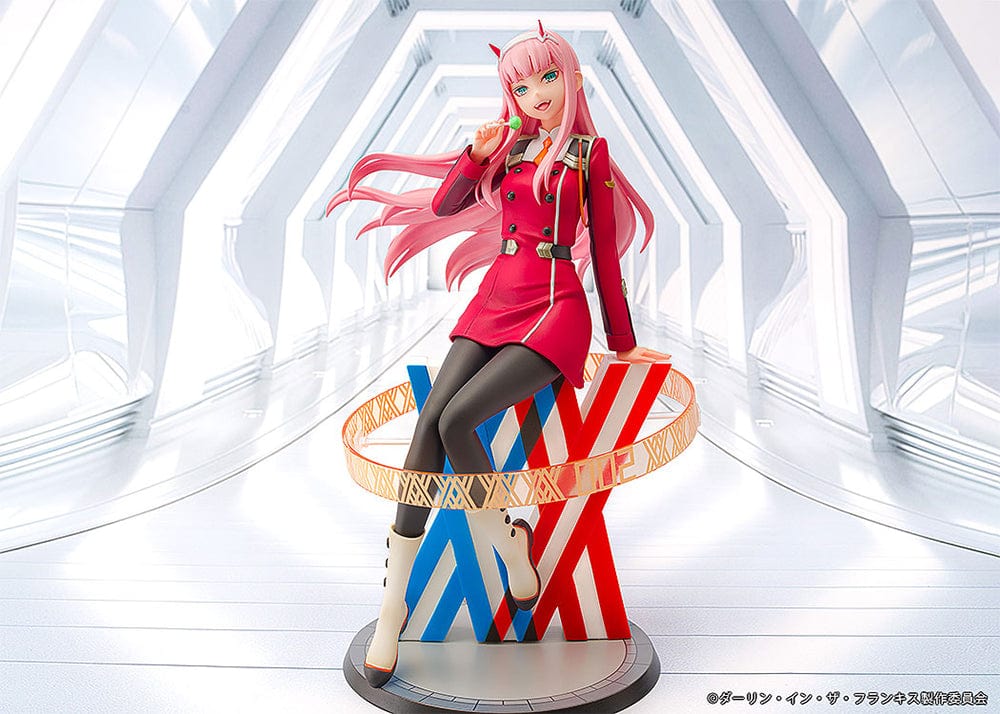 Darling in the Franxx Zero Two 1/7 Scale Figure in red outfit, sitting on a geometric base with "002" emblem, holding a lollipop with a mischievous expression.