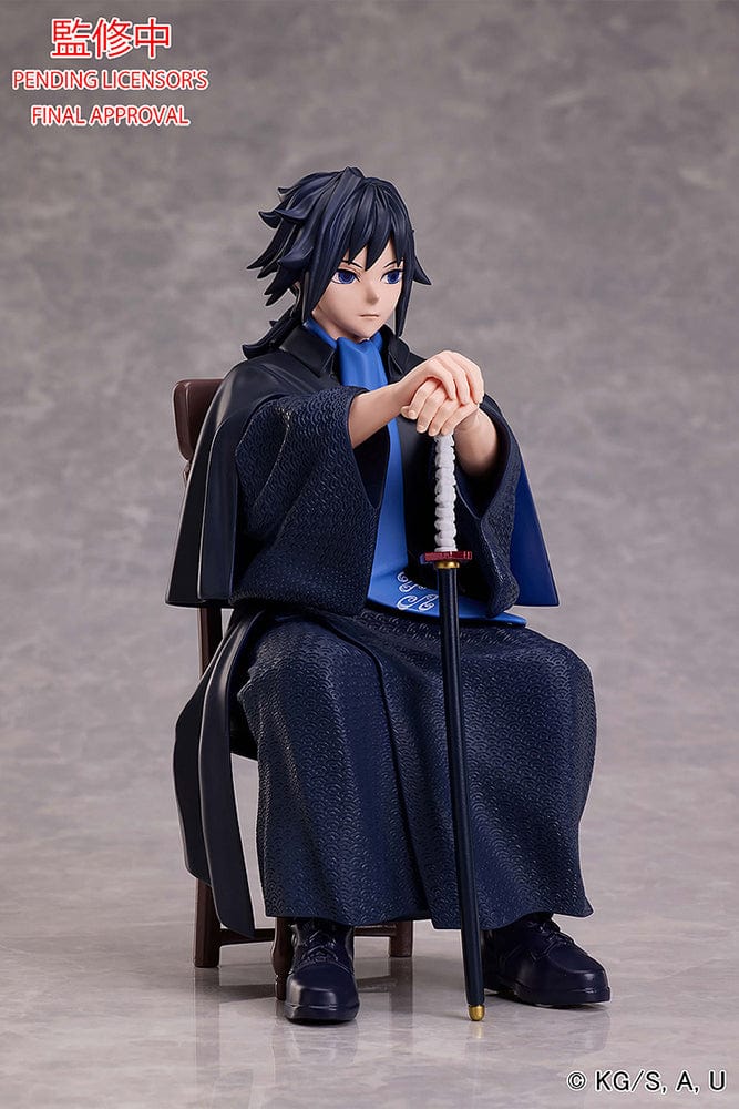 Demon Slayer: Kimetsu no Yaiba Giyu Tomioka figure seated with sheathed sword, wearing black and blue haori, showing calm and serious expression.