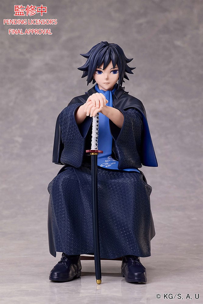 Demon Slayer: Kimetsu no Yaiba Giyu Tomioka figure seated with sheathed sword, wearing black and blue haori, showing calm and serious expression.