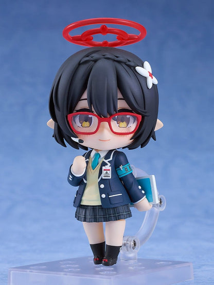 Blue Archive Nendoroid No.2657 Ayane Okusora in a school uniform, with red glasses, dark braided hair with a flower clip, and a red halo accessory, holding a book.