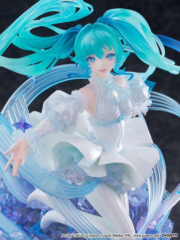 “Hatsune Miku (Crystal Dress Ver.) 1/7 scale figure—Miku in a white dress with translucent twin-tails, surrounded by swirling musical ribbons on a blue crystal base.”