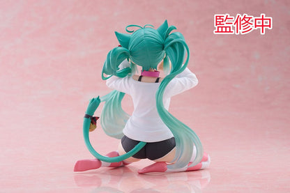 Hatsune Miku Desktop Cute Figure - Adorable and colorful figure of Hatsune Miku sitting playfully with a surprised expression, dressed in a casual leek-themed t-shirt and striped leg warmers, perfect for adding a touch of cuteness to any desk or shelf.