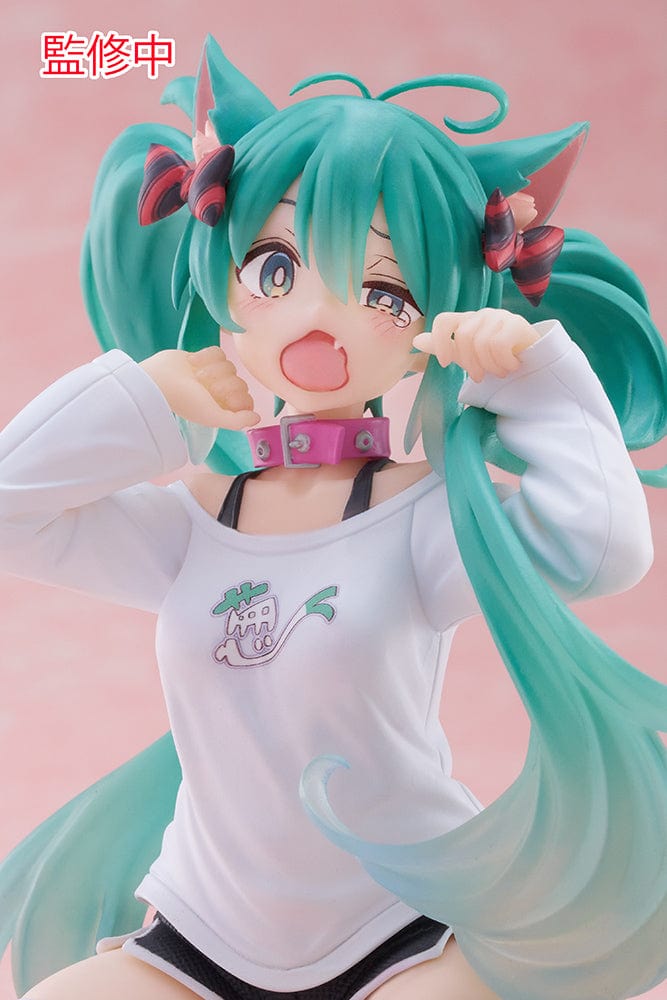 Hatsune Miku Desktop Cute Figure - Adorable and colorful figure of Hatsune Miku sitting playfully with a surprised expression, dressed in a casual leek-themed t-shirt and striped leg warmers, perfect for adding a touch of cuteness to any desk or shelf.