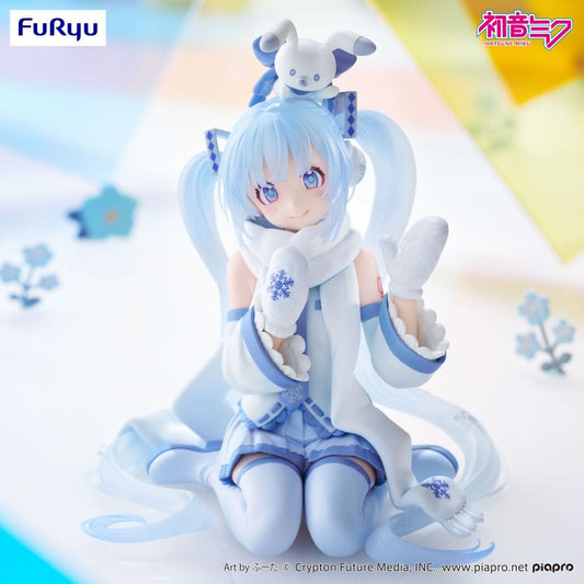 Snow Miku (Sky Town 10th Ver.) figure sitting in a kneeling pose with mittens and scarf, wearing pastel blue and white winterwear.

