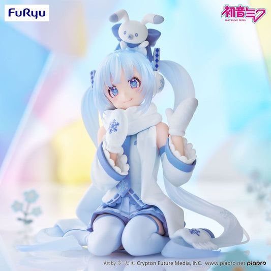 Snow Miku (Sky Town 10th Ver.) figure sitting in a kneeling pose with mittens and scarf, wearing pastel blue and white winterwear.

