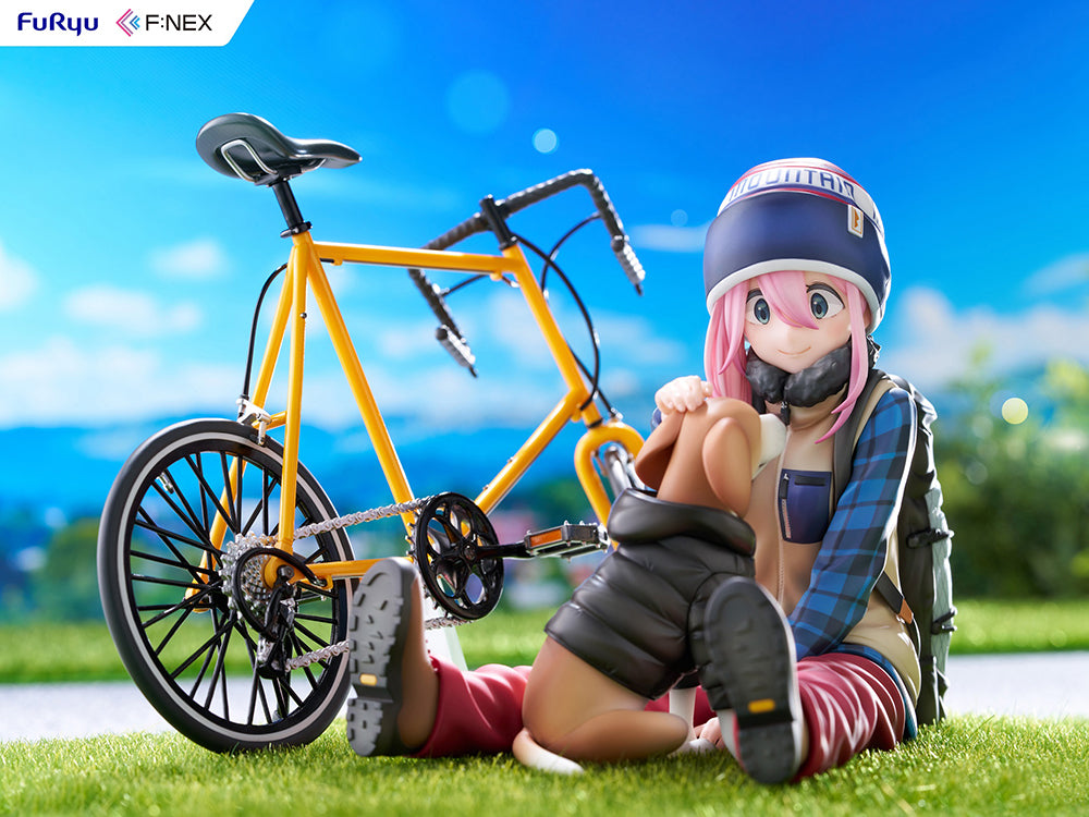 Nadeshiko Kagamihara (Season 3) 1/7 Scale Figure, depicting the character seated beside a yellow bicycle with detailed camping gear on a grassy base, capturing her joyful and carefree nature.